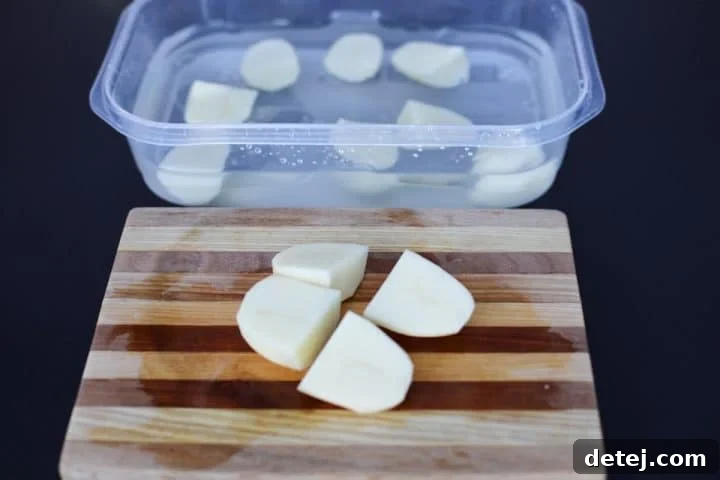 quartered potatoes on a cutting board.
