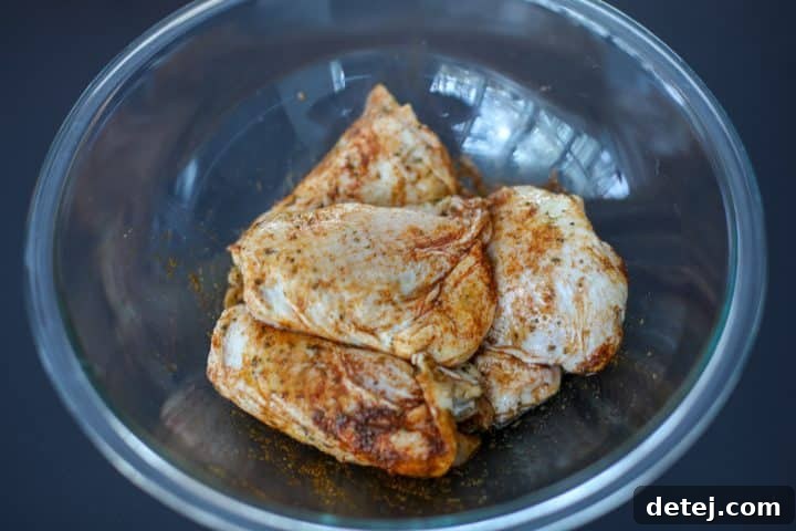 spice rubbed chicken thighs in a bowl, ready for searing.