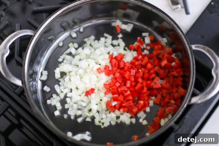 onions and peppers sautéing in a pan.
