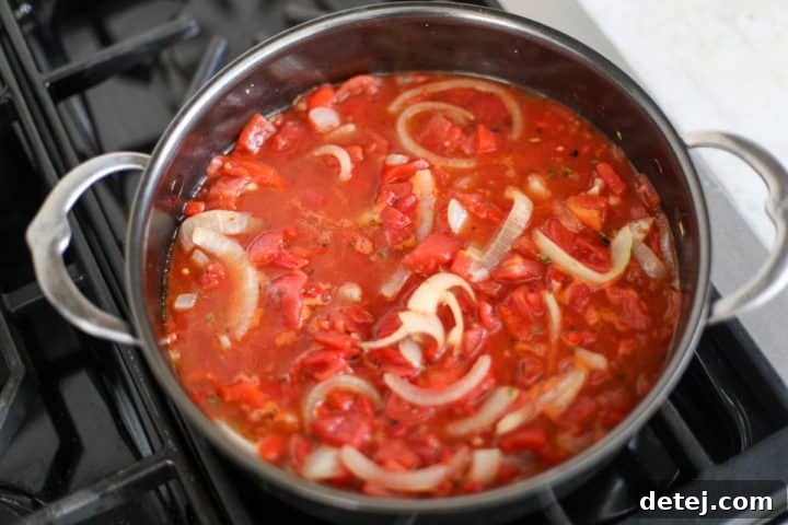 Smoky Red Pepper Shrimp Pasta 10 The red pepper and tomato sauce simmering gently in a pan on the stovetop.