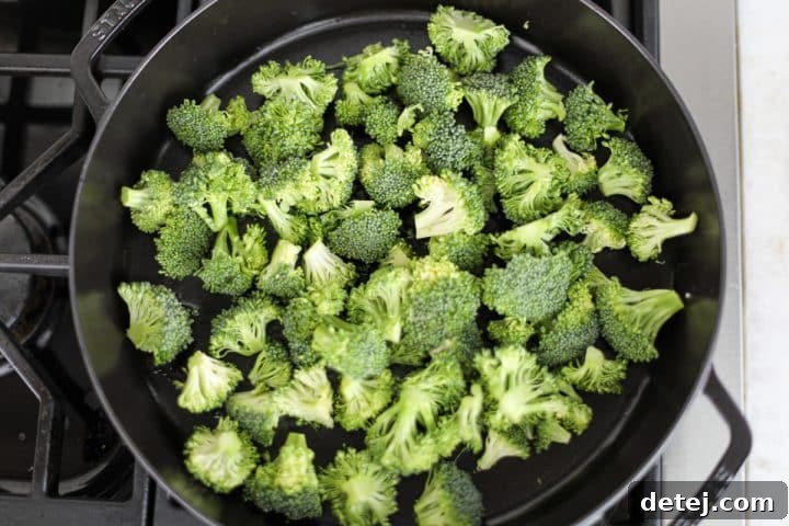 Broccoli florets sautéing in a hot pan.