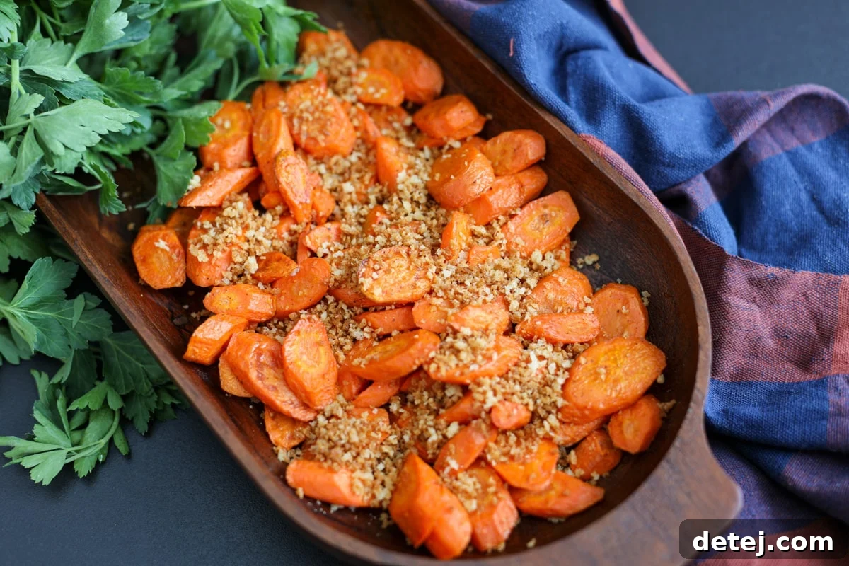 Crispy oven roasted carrots in a serving dish, garnished with fresh herbs.