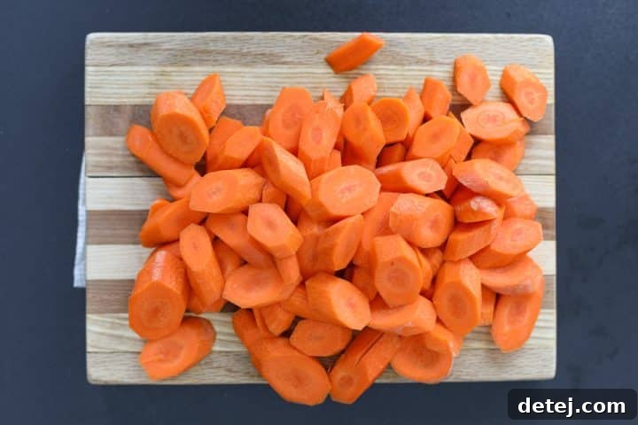 Carrots sliced diagonally on a cutting board.
