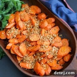Crispy oven roasted carrots in a serving bowl with toasted breadcrumbs.
