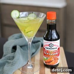 A vibrant Teriyaki Tini cocktail, garnished with a delicate cucumber ribbon, ready to be enjoyed.