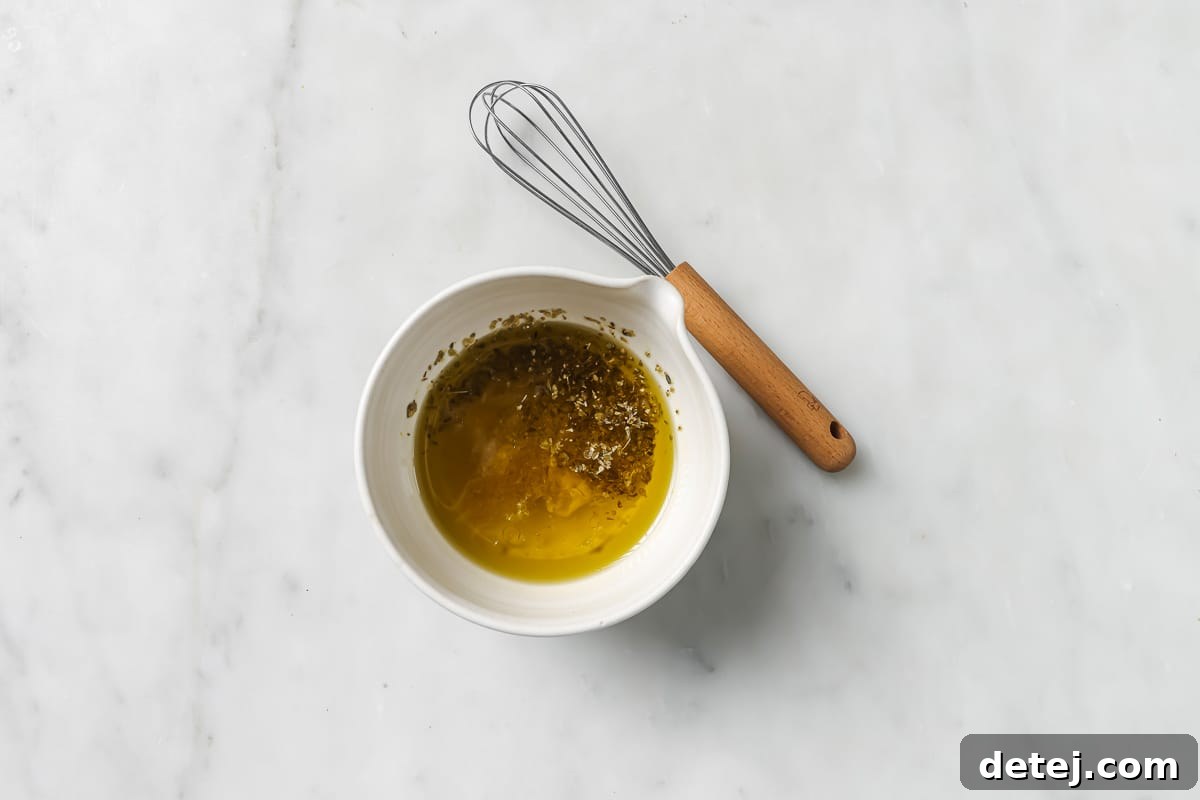 Close-up of the homemade lemon vinaigrette dressing in a jar, ready to be poured over the salad.