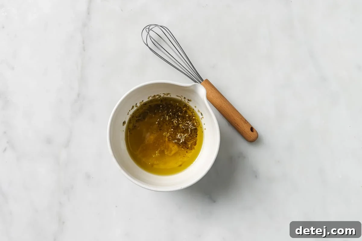 Close-up of the fresh lemon vinaigrette dressing being whisked in a glass bowl.