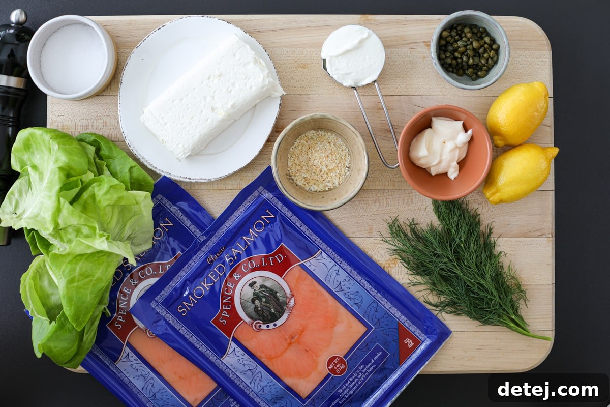 Fresh ingredients laid out for making Smoked Salmon Ring, including smoked salmon, cream cheese, lemon, dill, and capers.