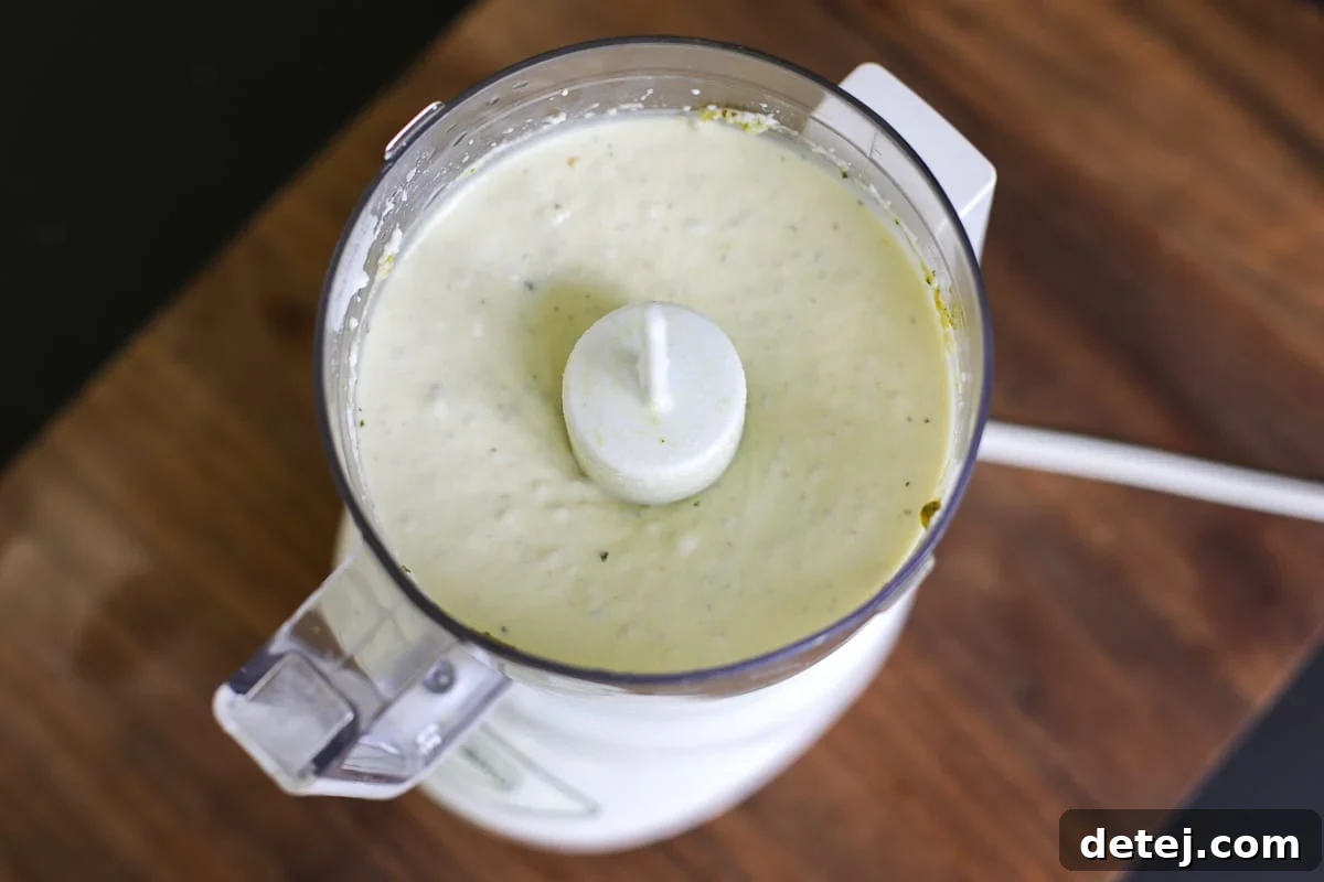 Whipped pesto ricotta in a food processor, ready to be blended.