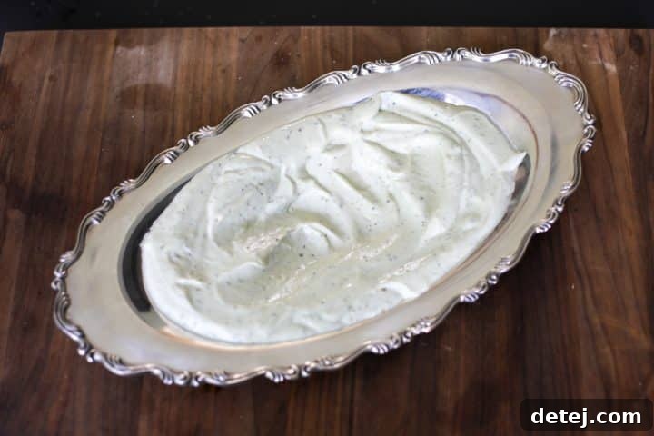 Whipped pesto ricotta in a serving dish, ready for topping.