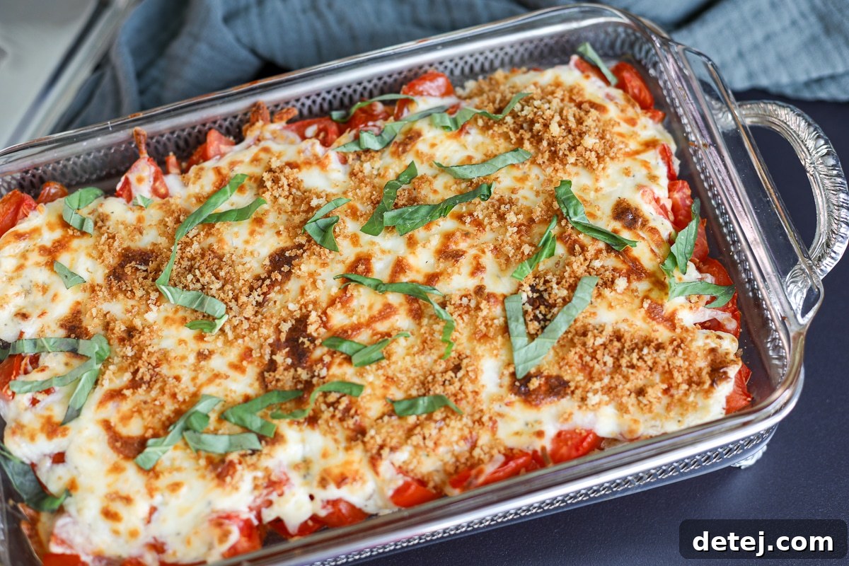A beautifully presented tomato pie dip in a rustic server, garnished with fresh basil.