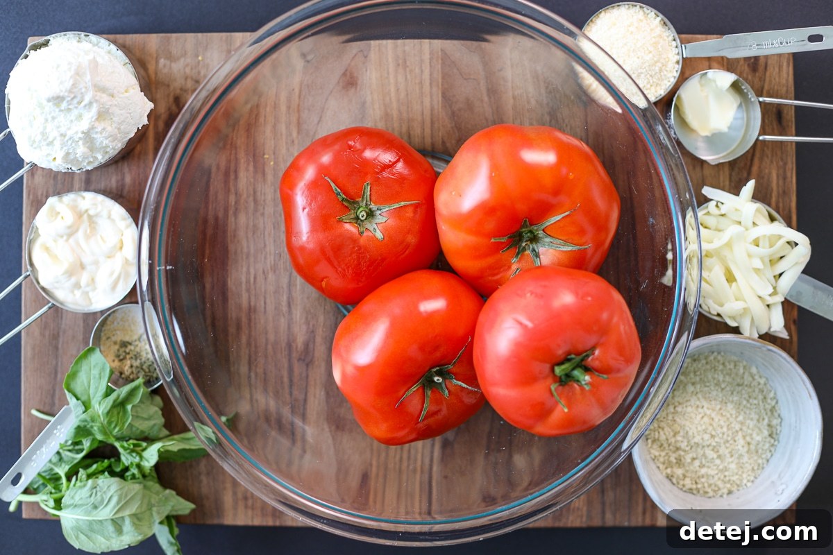 A selection of fresh ingredients, including ripe tomatoes, cheese, and herbs, laid out for tomato pie dip preparation.