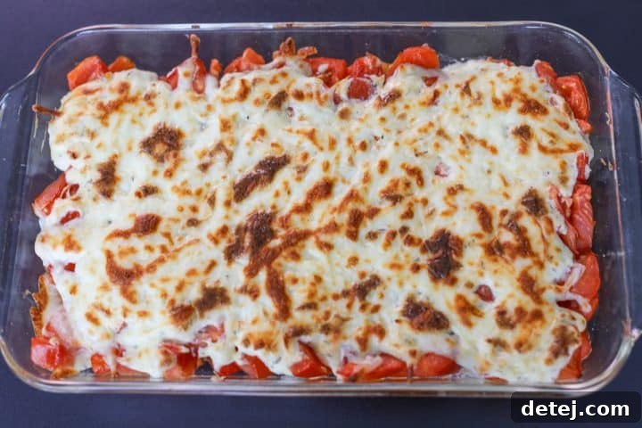 Tomato pie dip fresh from the oven, showing a perfectly crispy and bubbly cheese top.