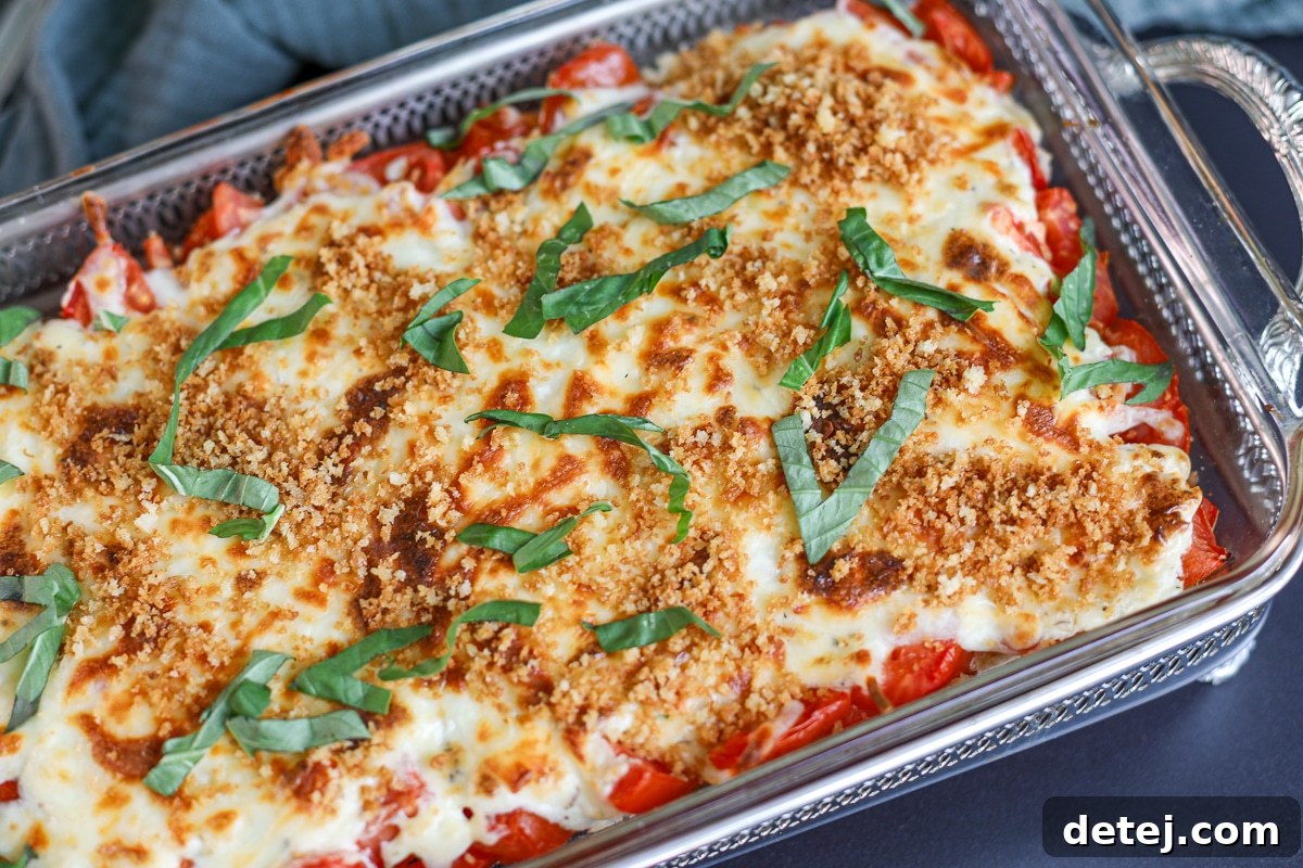 Close-up of a serving of Tomato Pie Dip, highlighting the toasted panko, fresh basil, and melted cheese.
