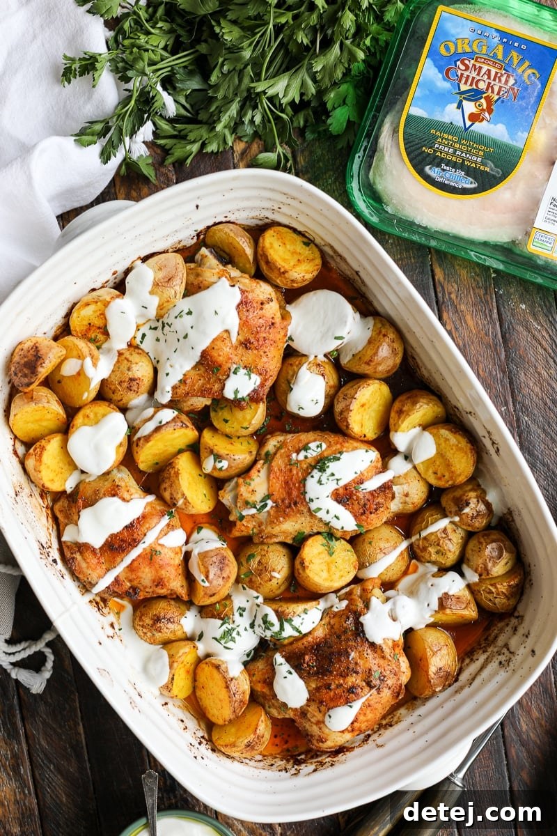 One Pan Roasted Chicken and Potatoes on a sheet pan next to Smart Chicken packaging, emphasizing quality ingredients.