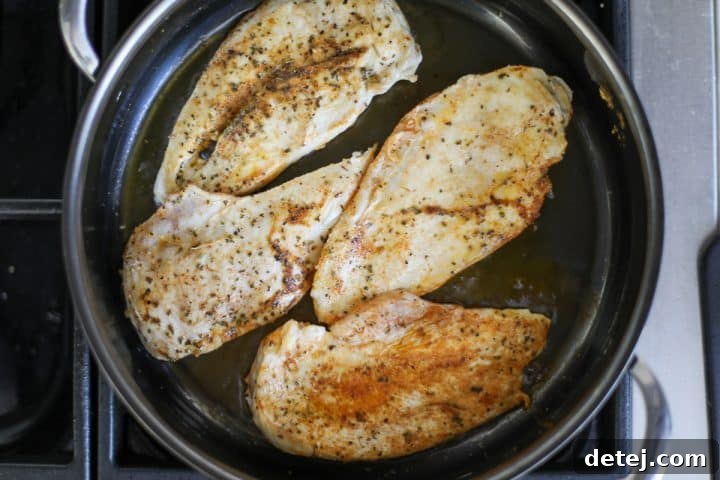 Perfectly cooked and seared blackened chicken in a pan.