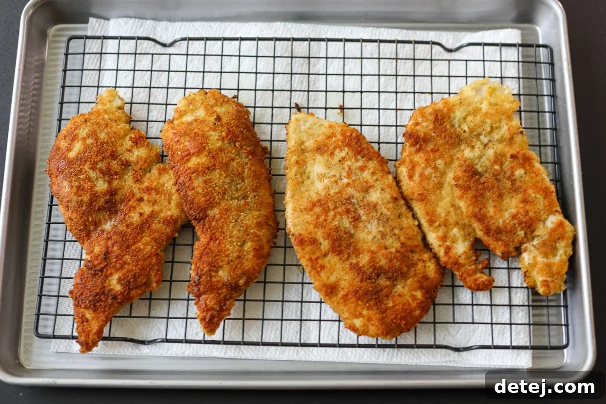 Agile Chicken Cutlets 8 Cooked Walking Chicken Cutlets resting on a cooling rack to maintain crispiness.