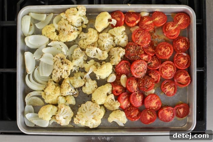 sheet pan with mixed vegetables drizzled with olive oil.