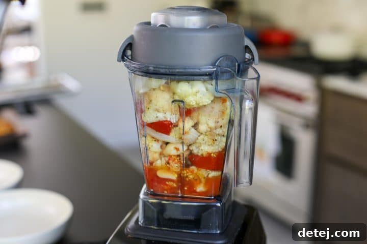 blender filled with roasted vegetables and cottage cheese.