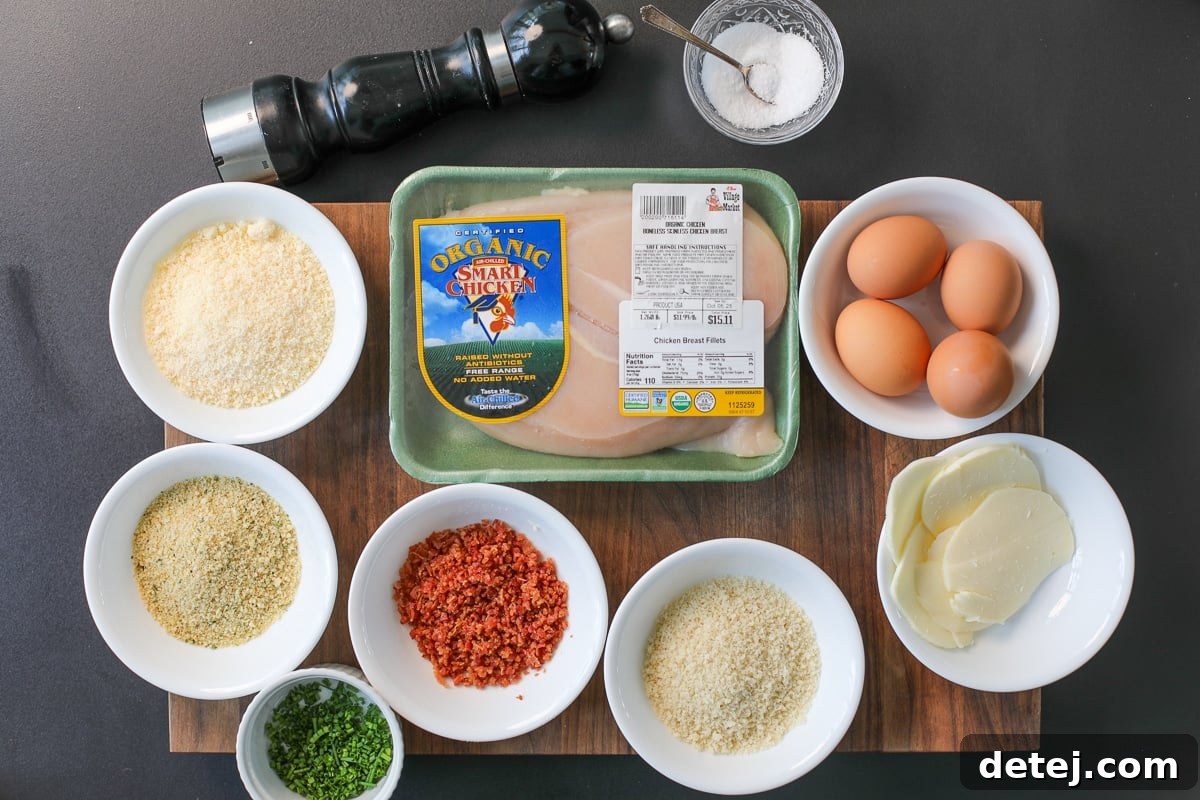 Ultimate Breakfast Chicken Cutlets 3 ingredients needed for bacon egg and cheese chicken cutlets displayed on a wooden board.