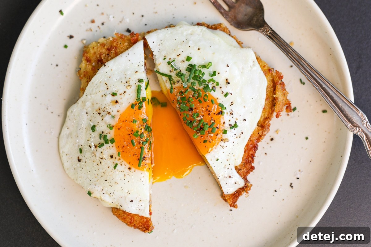 Ultimate Breakfast Chicken Cutlets 4 Bacon egg and cheese cutlets on a plate, garnished with fresh chives, showcasing the melted cheese and fried egg.