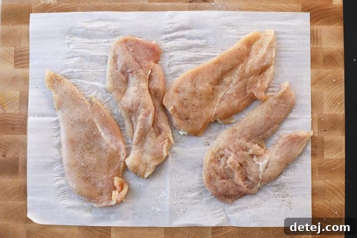 Seasoned and breaded chicken cutlets on a plate, ready for frying.