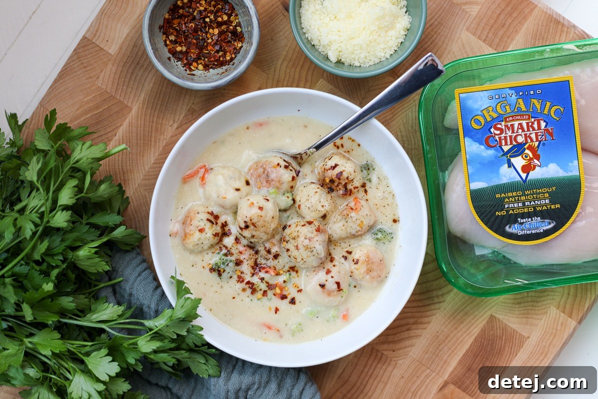 A bowl of healthy broccoli cheddar soup with Smart Chicken packaging in the background.
