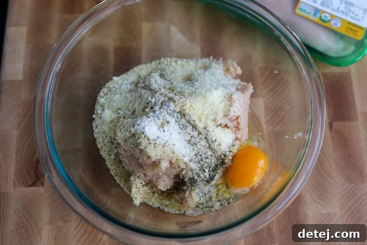 A bowl of mixed chicken meatball ingredients before forming.