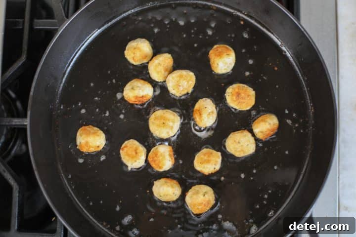 Golden brown pan-fried mini chicken meatballs.