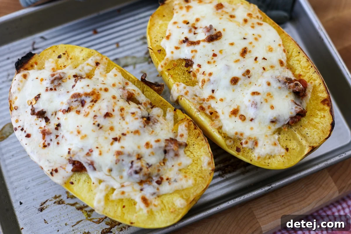 Spaghetti Squash Protein Beef Boats on a baking tray, showcasing a golden, cheesy topping.