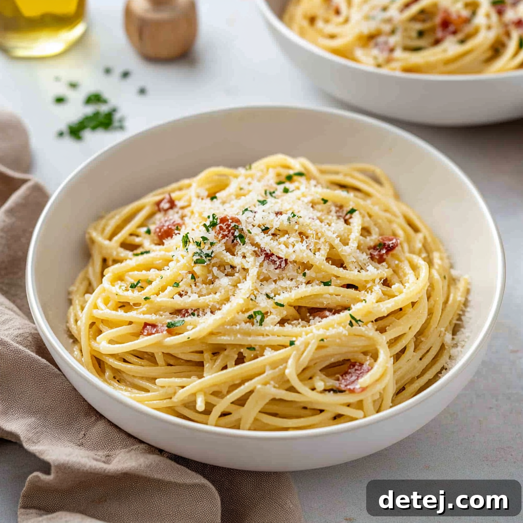 Close-up of freshly served Spaghetti Carbonara in a white bowl, garnished with fresh parsley and grated Parmesan cheese.
