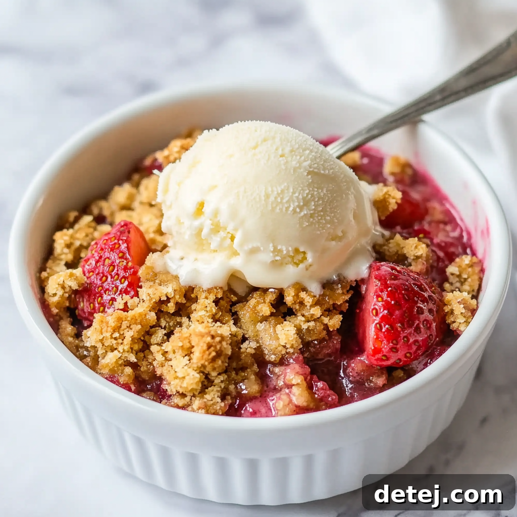 Rhubarb Strawberry Crumble topped with a generous scoop of vanilla ice cream.