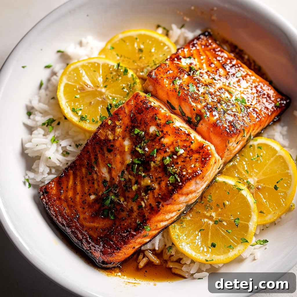 Close-up of perfectly cooked honey glazed salmon fillets, glistening with a rich sauce and garnished with fresh parsley and lemon wedges, alongside a steaming bowl of coconut rice and vibrant green asparagus spears.