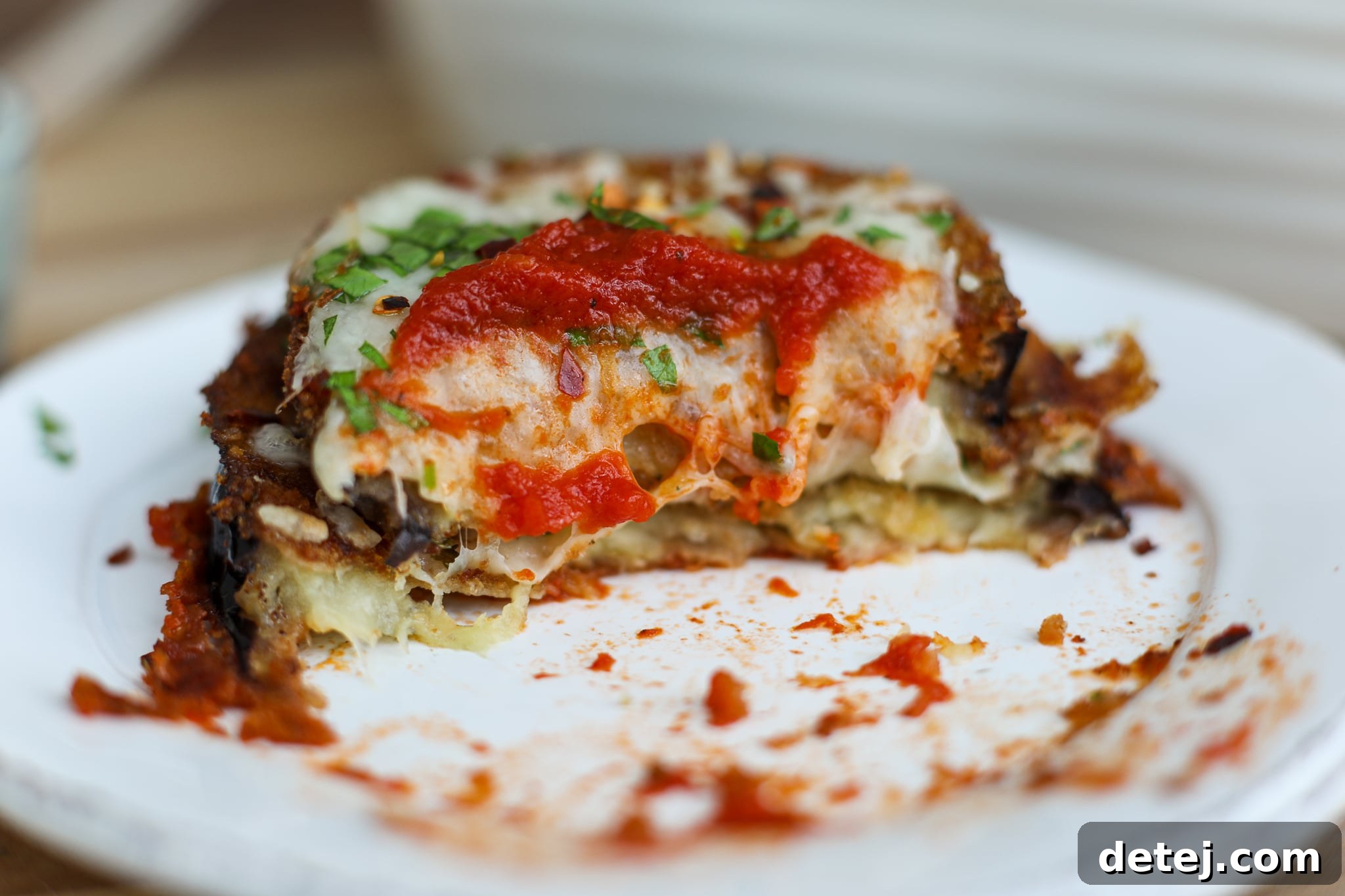 Close-up of a serving of Easy Eggplant Parmesan with fresh basil.