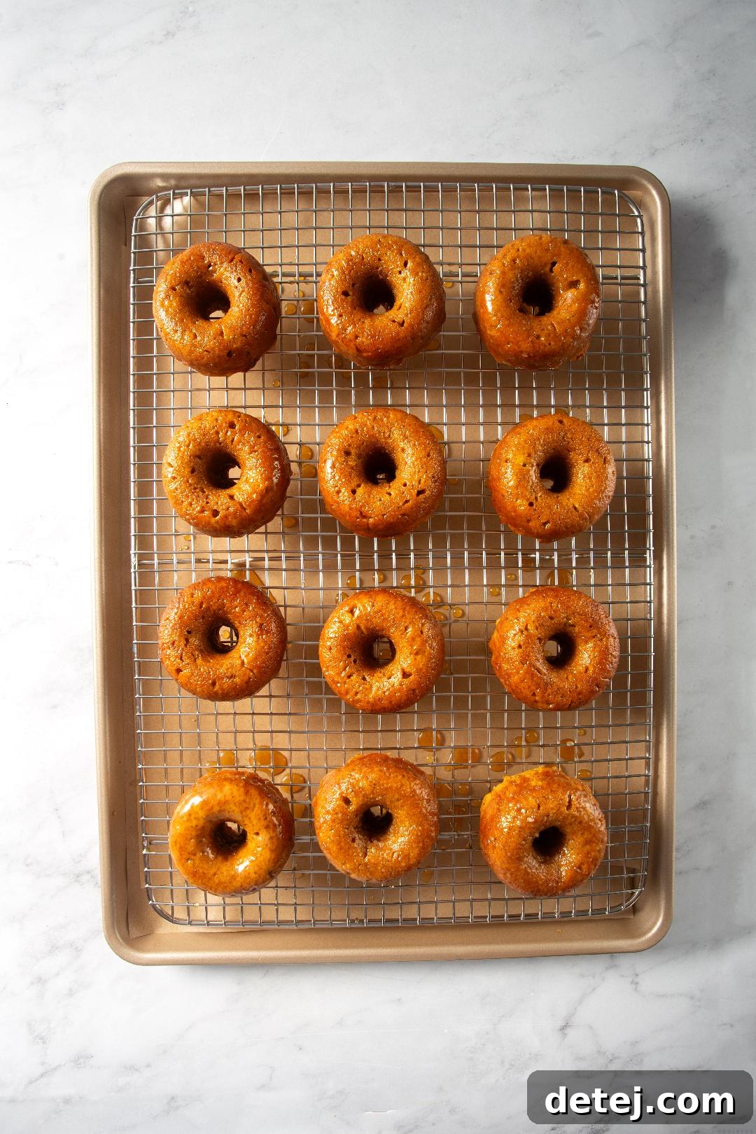Freshly baked pumpkin donuts cooling on a wire rack, ready for glazing