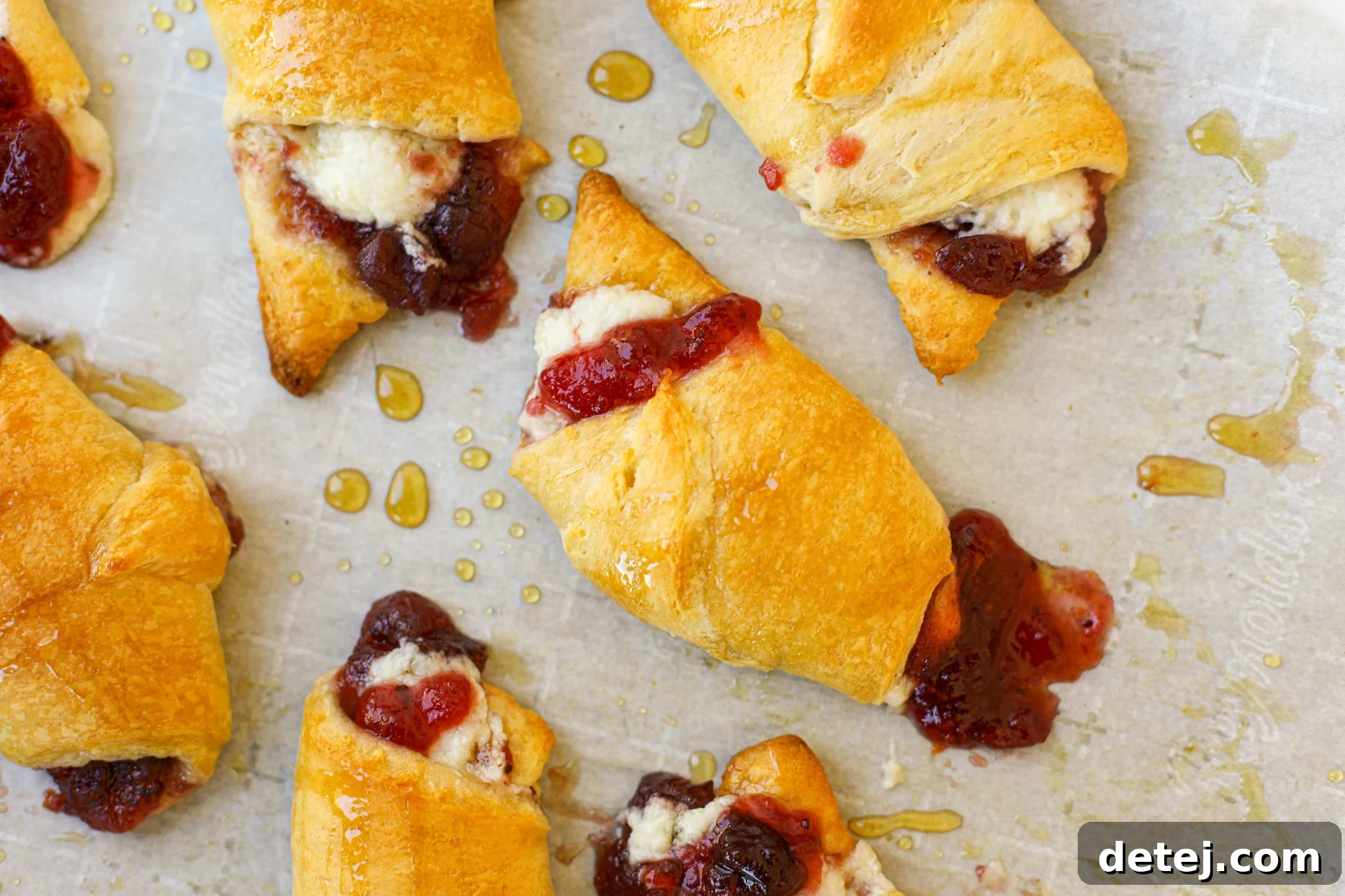 Golden brown Cranberry Cream Cheese Roll-Ups on a baking sheet, ready to be served, perfect for any occasion.