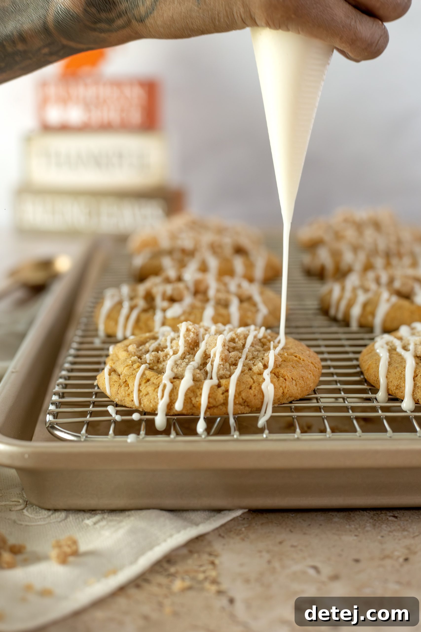 Drizzling maple glaze over pumpkin streusel cookies