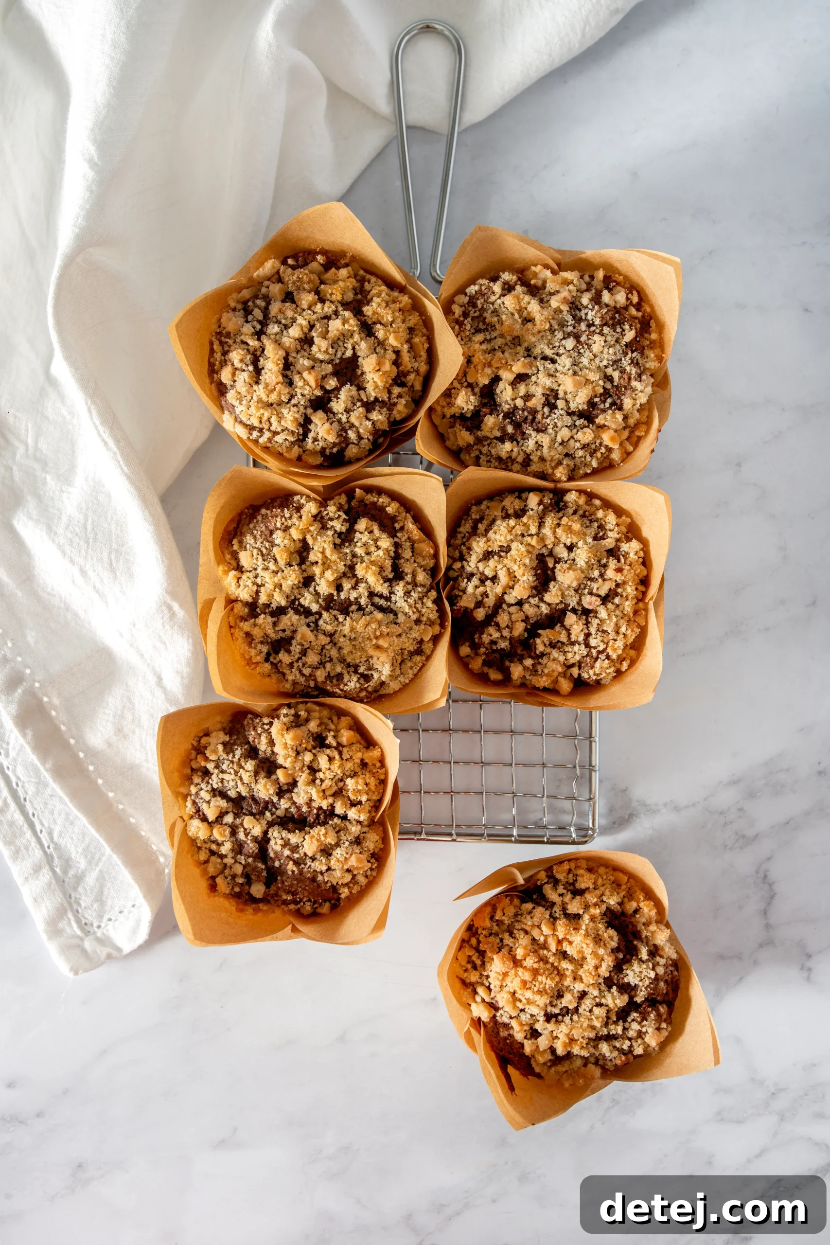 Decadent dark chocolate muffins with a golden, crunchy toffee crumble topping, ready to be enjoyed.
