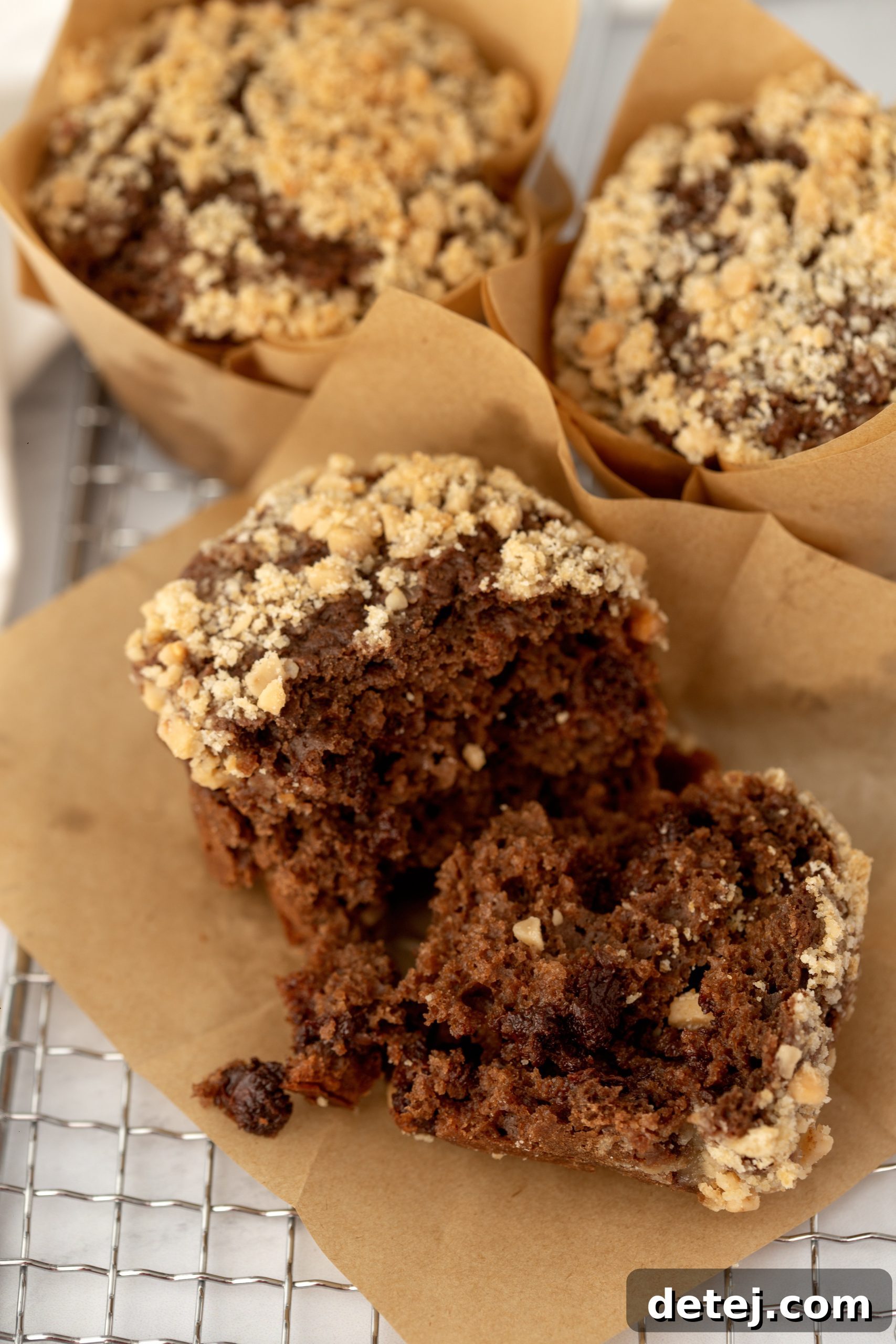 Freshly baked chocolate muffins with toffee crumble cooling on a wire rack, ready to be served.