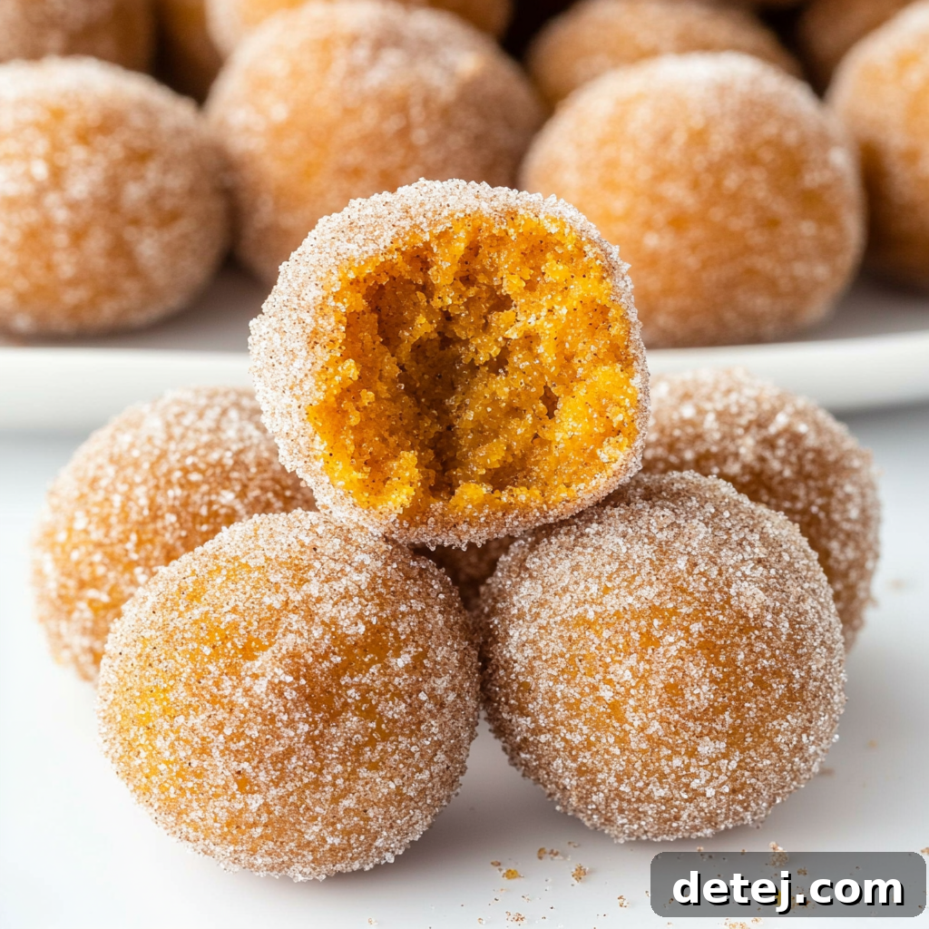 A beautifully arranged platter of Cinnamon Sugar Pumpkin Donut Holes, with a bowl of cream cheese dip, ready for a cozy autumn gathering.