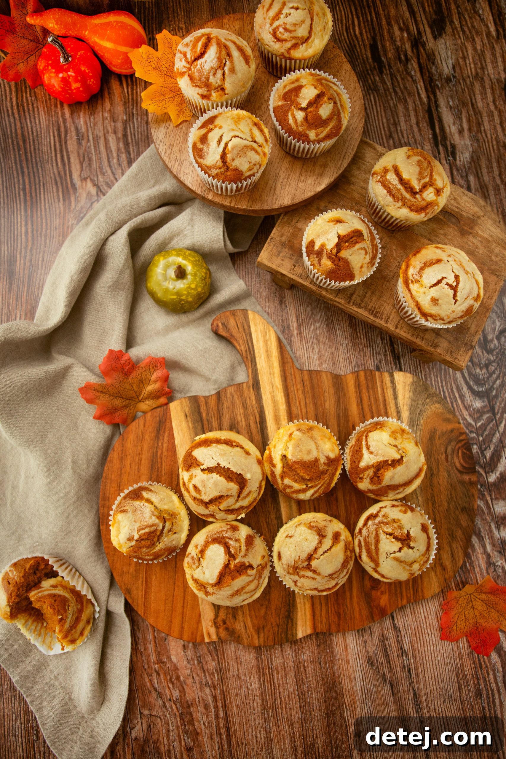 A close-up of a pumpkin cheesecake swirl muffin with a bite taken out, showing the creamy swirl inside.