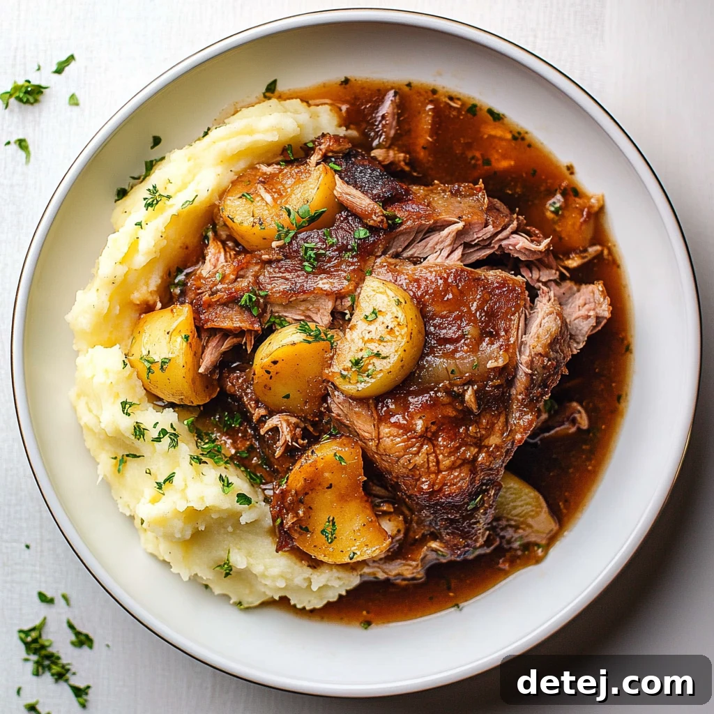 Close-up of apple cider pork roast being served with apples and onions.