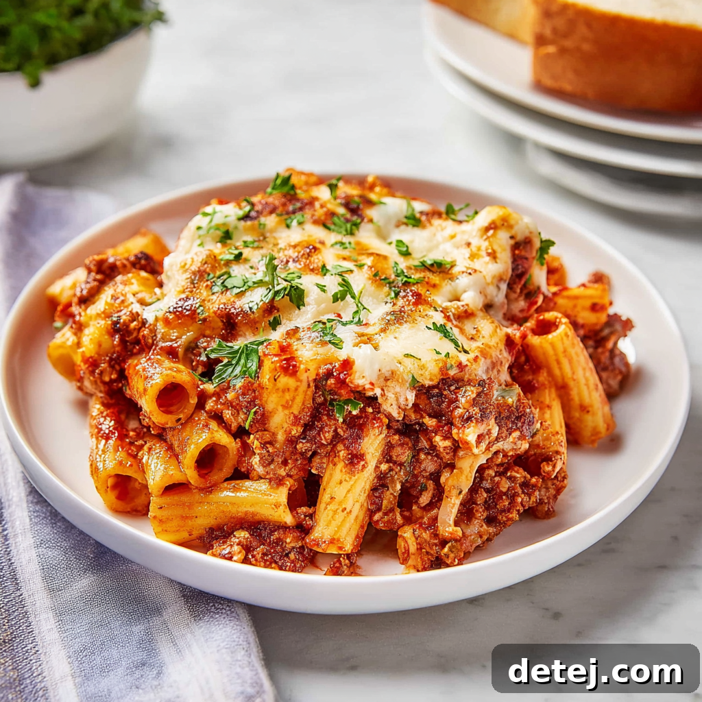 Easy Cheesy Baked Ziti served with fresh basil garnish.
