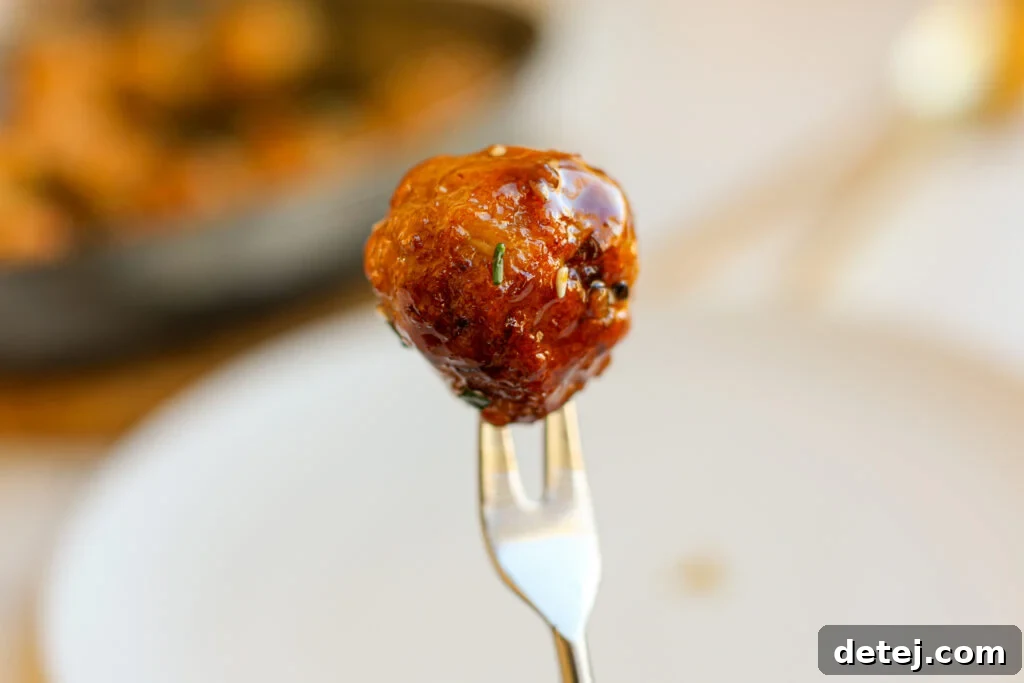 Sticky & Saucy Asian Meatballs 4 A bowl of glossy, rich soy glaze for Asian meatballs, with minced aromatics visible.