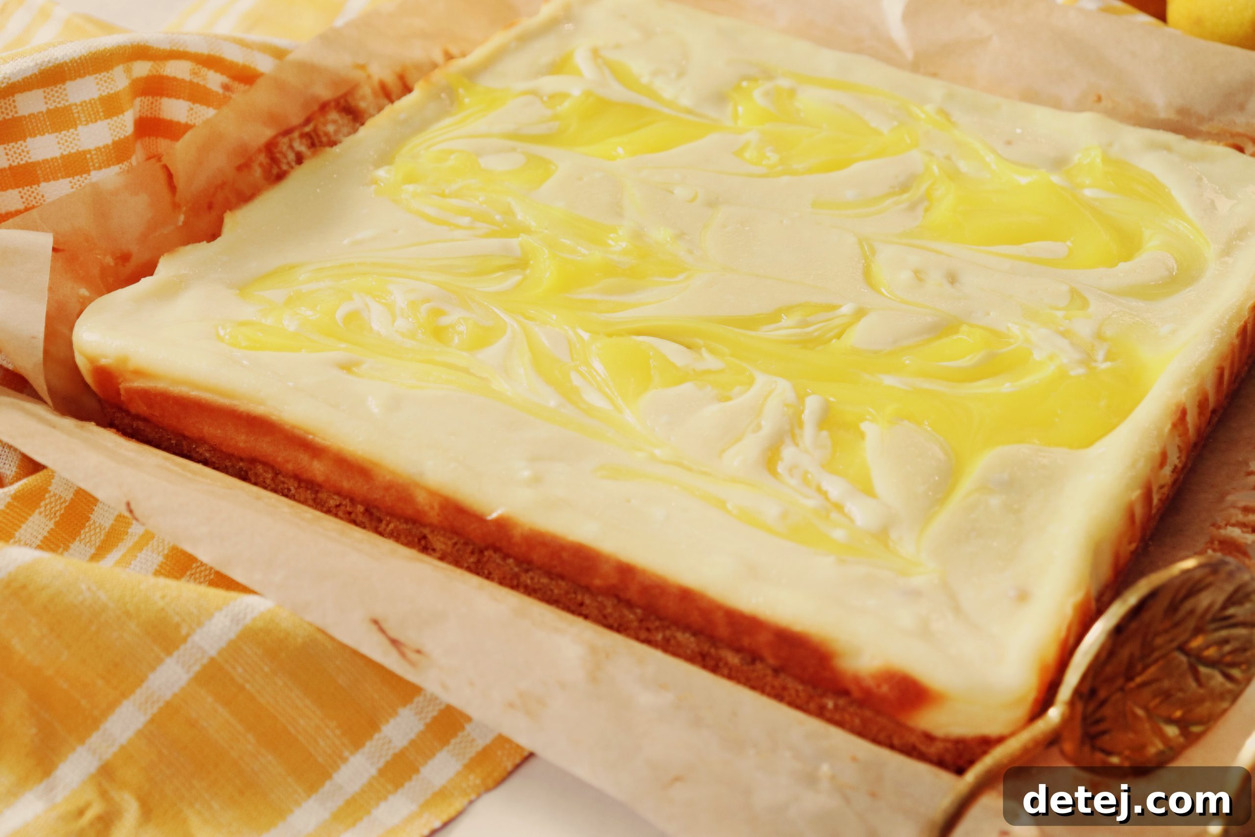 A top-down view of Lemon Swirl Cheesecake Bars, showcasing the creamy texture and vibrant lemon swirls, ready to be sliced.