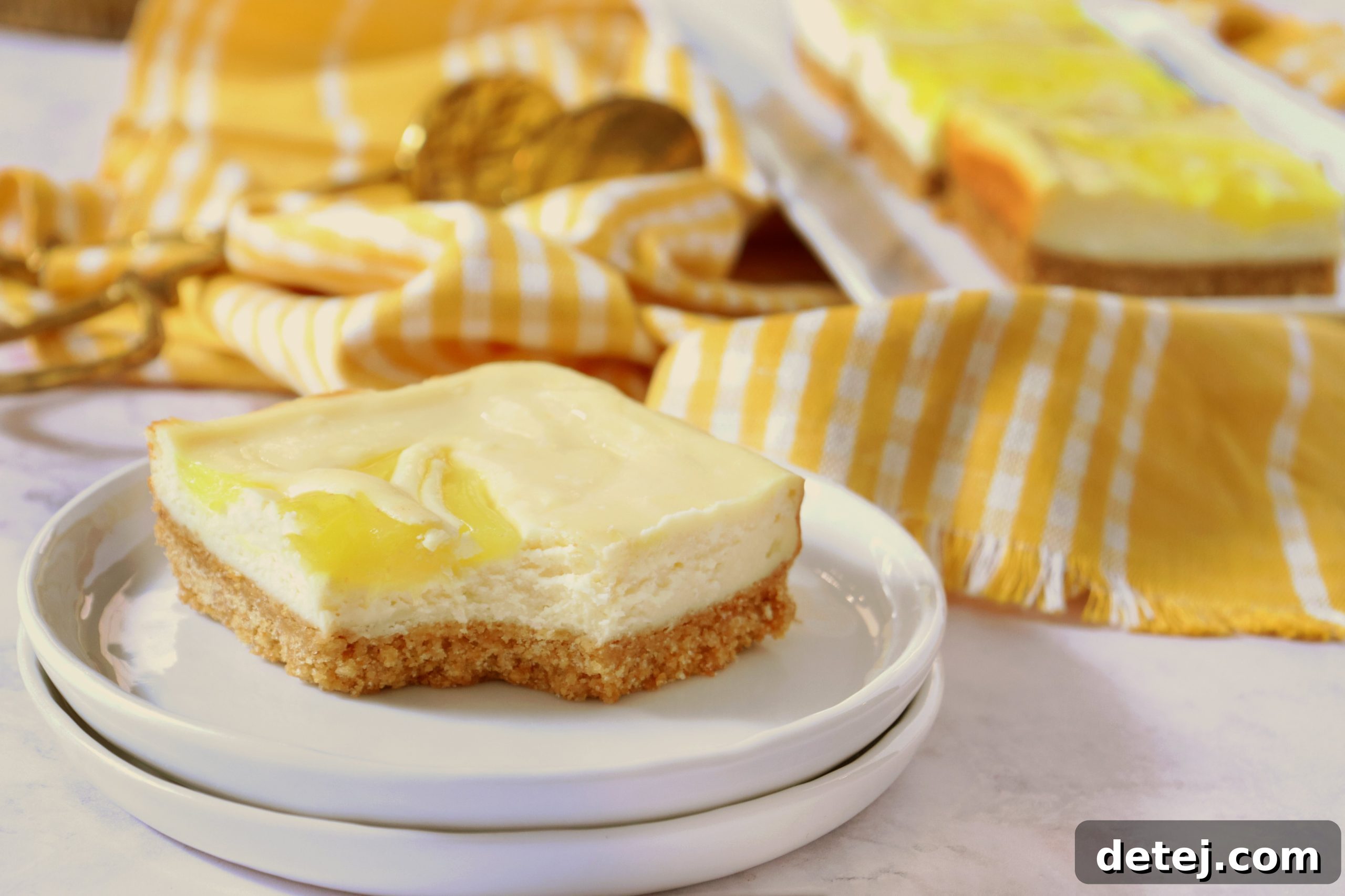 Freshly sliced Lemon Swirl Cheesecake Bars on a cutting board, showcasing their neat edges and vibrant lemon pattern.
