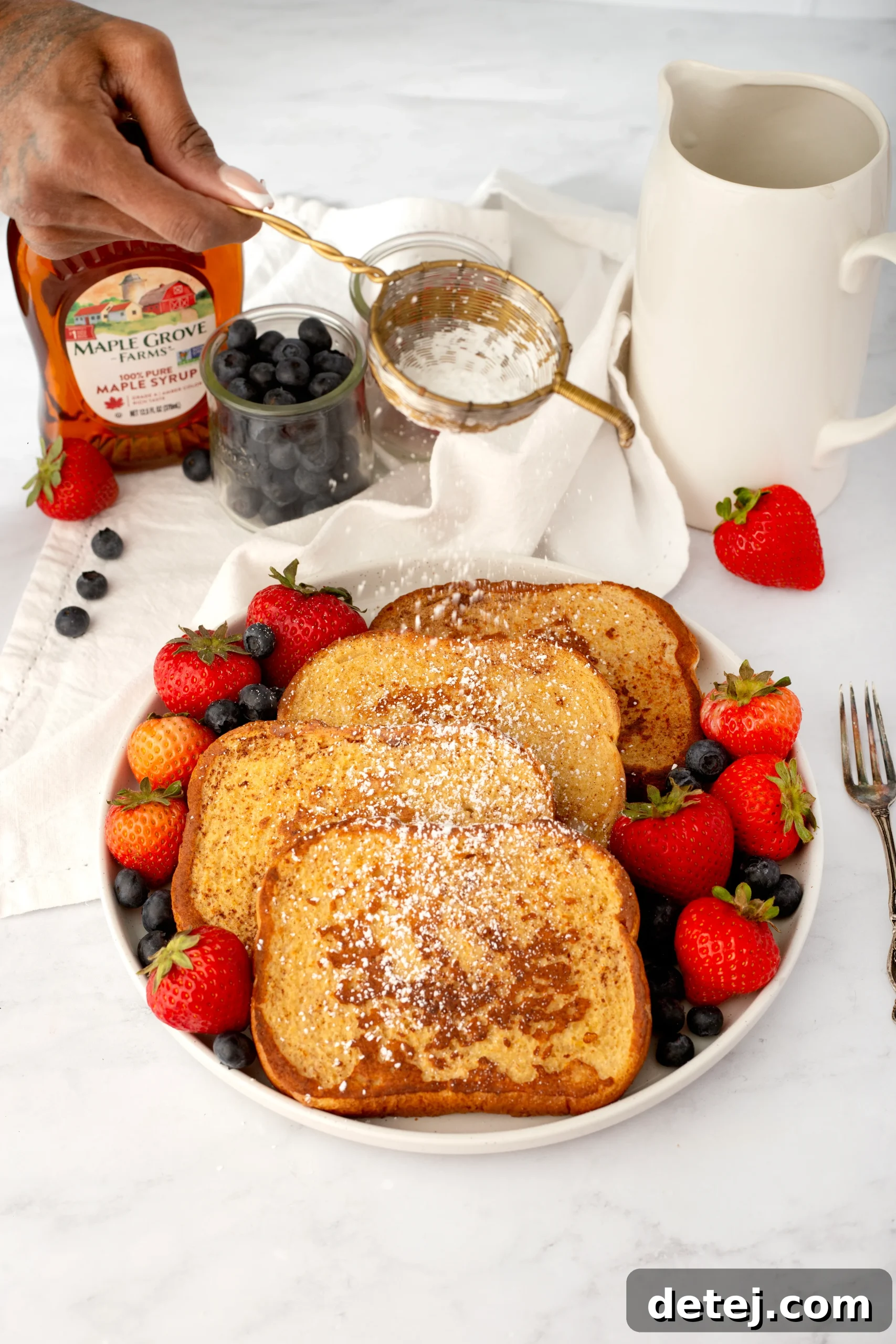French Toast served with fresh berries, powdered sugar, and a drizzle of maple syrup.