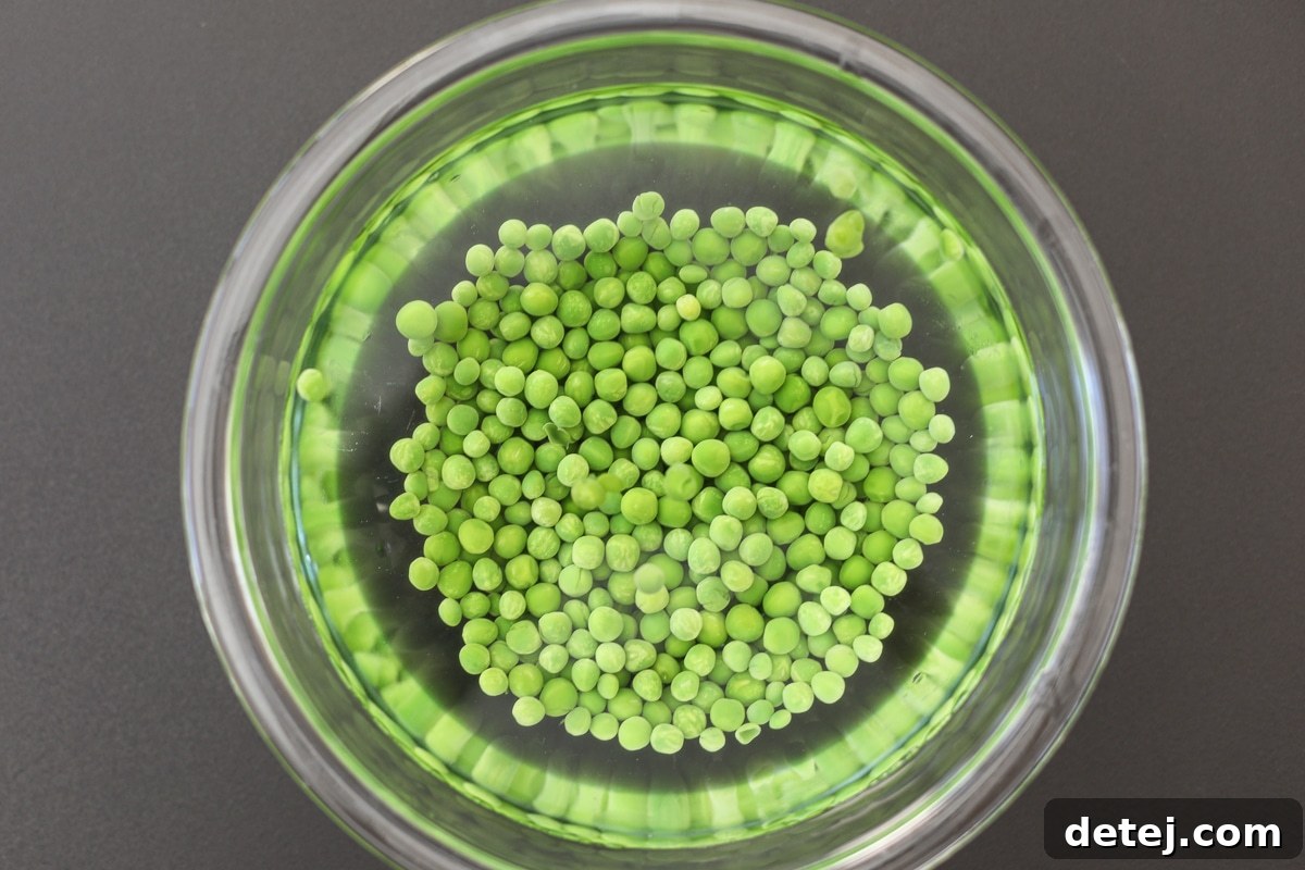 Blanched peas cooling rapidly in a bowl of ice water.