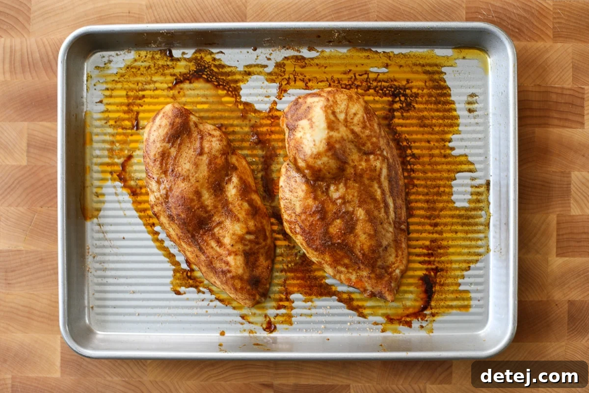 Fully cooked chicken breasts resting on a cutting board.