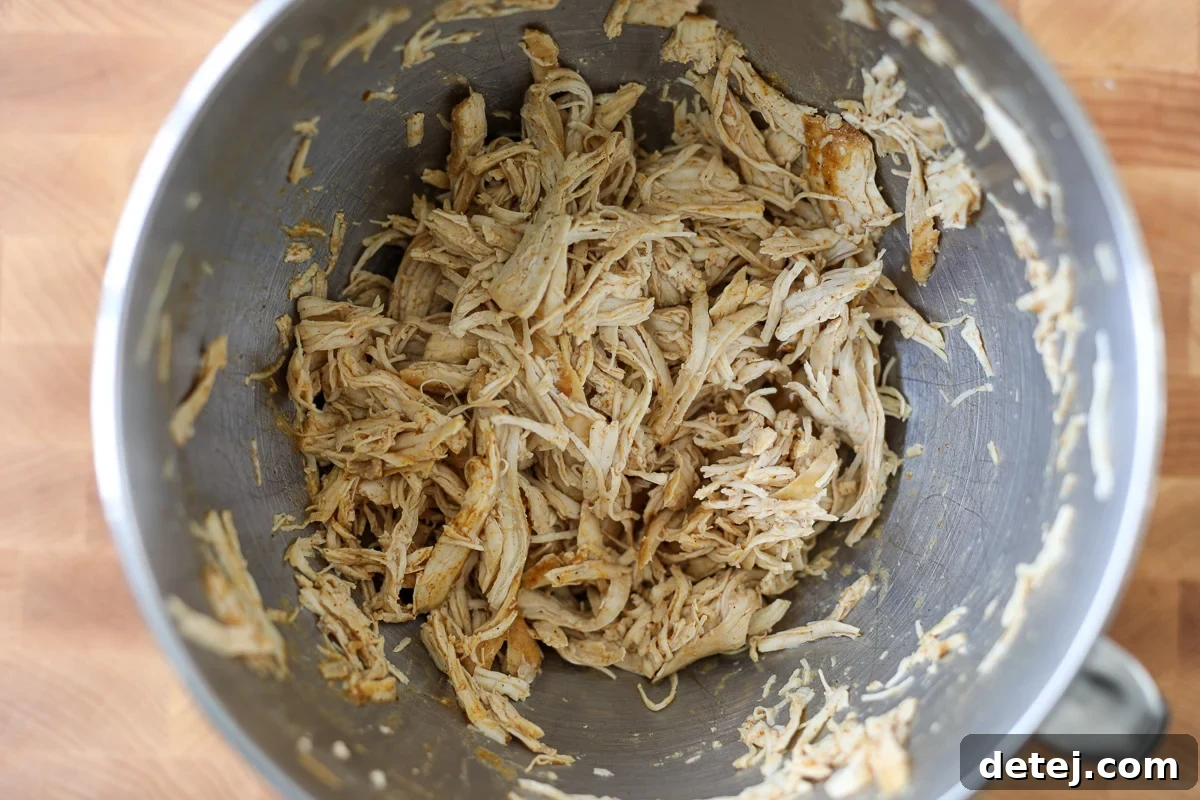 Shredded chicken in a mixing bowl, perfectly prepared.